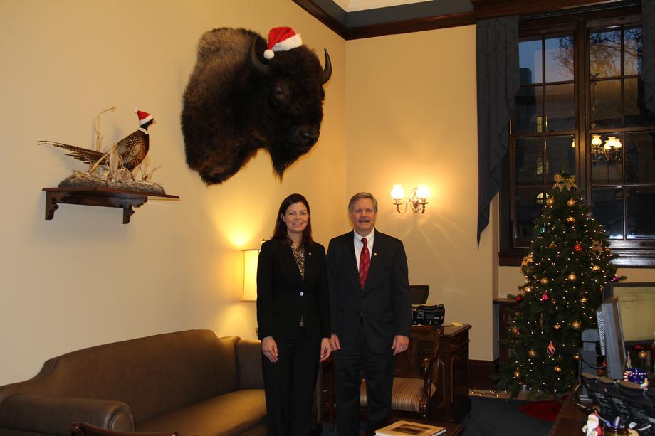 Christmas in the Senate-December 2011- Senators Hoeven and Kelly Ayotte (R-NH) pose in front of festive mounts in Hoeven's front office. Both Senators display animals from their respective home states in their offices.